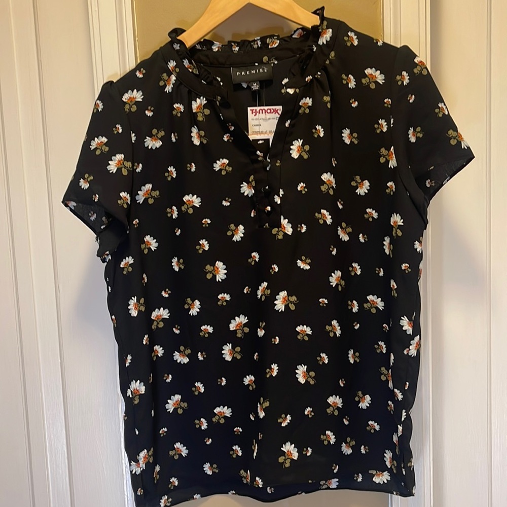Black polyester blouse with floral design.